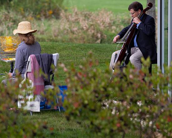 Benjamin Whitcomb playing for a painter outdoors